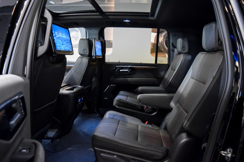 Inside a 2024 Chevrolet Suburban: black leather bucket seats in the middle row with rear entertainment screens