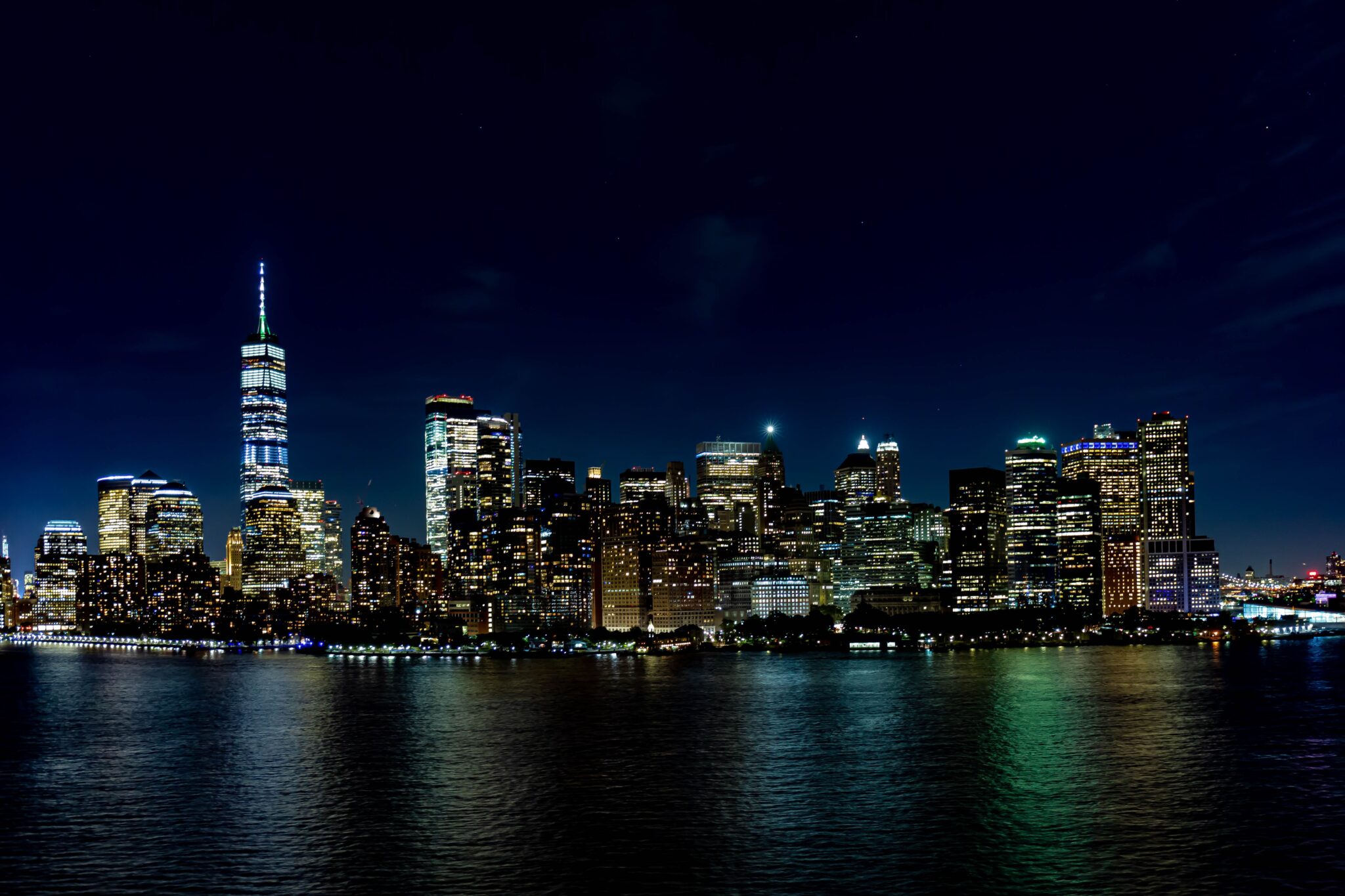 The Manhattan skyline lit up at night across the water
